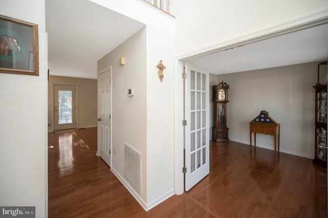 a view of a hallway with wooden floor and closet