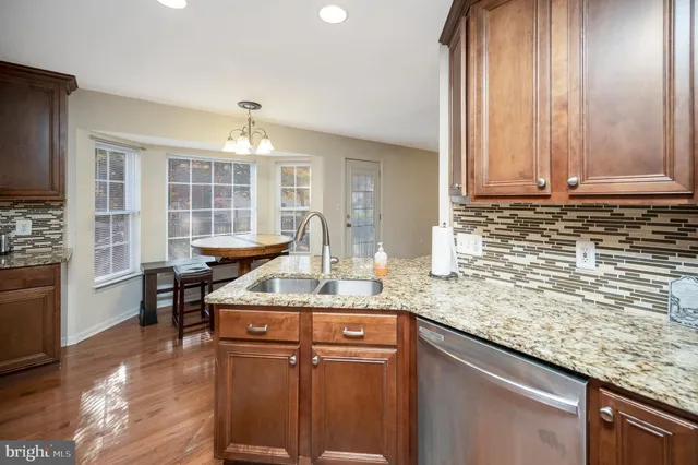 a kitchen with stainless steel appliances granite countertop a sink stove and cabinets