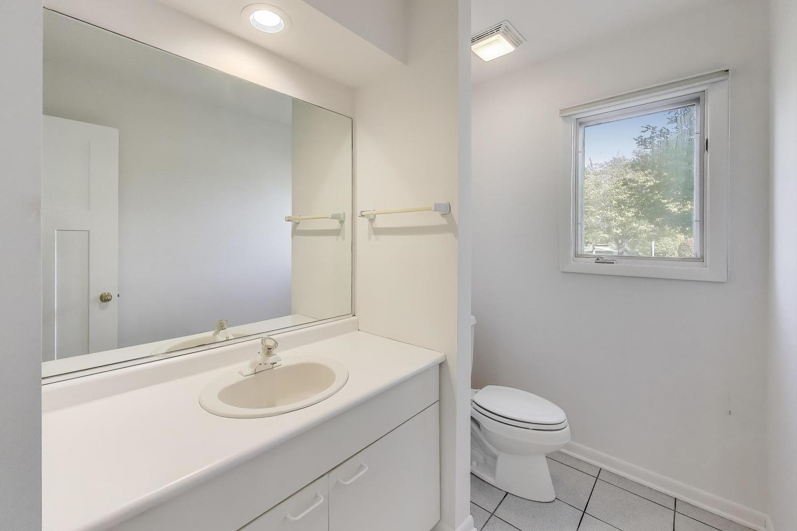 1903 Sheridan Road Buffalo Grove, IL 60089 - Photo 12 of 33 a bathroom with a sink toilet and a mirror