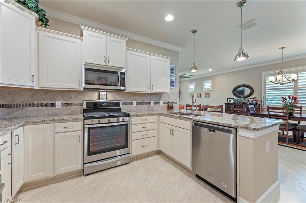 20191 Torch Key Way Estero, FL 33928 - Photo 12 of 39 a kitchen with cabinets appliances a sink and a counter top space