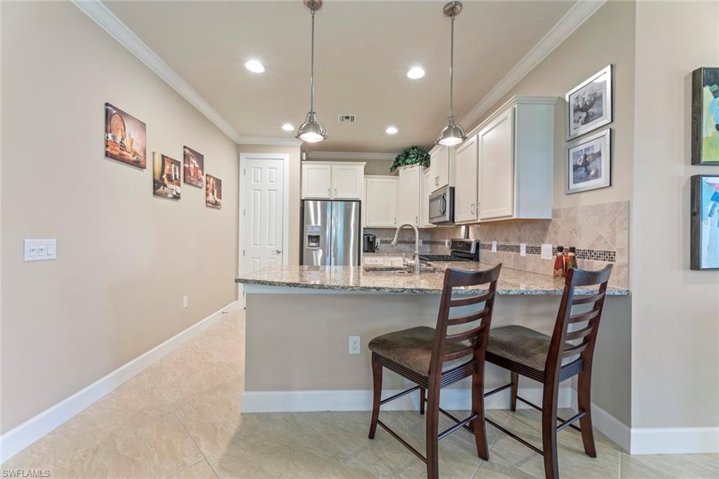 20191 Torch Key Way Estero, FL 33928 - Photo 13 of 39 a kitchen with kitchen island stainless steel appliances a dining table and chairs