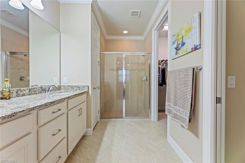 20191 Torch Key Way Estero, FL 33928 - Photo 16 of 39 a bathroom with a granite countertop sink a mirror a shower and vanity
