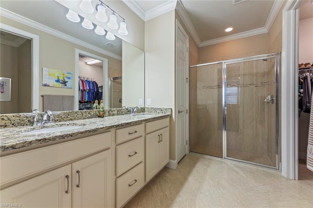 20191 Torch Key Way Estero, FL 33928 - Photo 17 of 39 a bathroom with a granite countertop sink a mirror and a shower