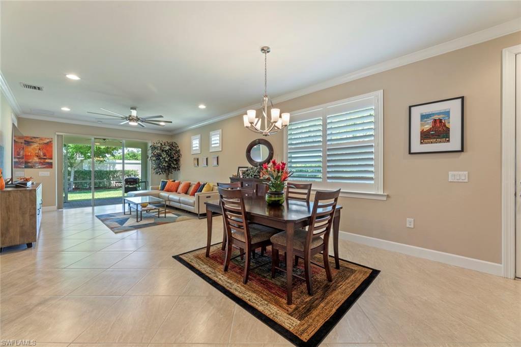 20191 Torch Key Way Estero, FL 33928 - Photo 6 of 39 a view of a dining room and livingroom with furniture wooden floor a rug and a chandelier