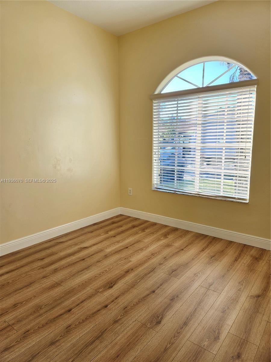 14209 Southwest 160th Court Miami, FL 33196 - Photo 20 of 24 a view of an empty room with wooden floor and a window