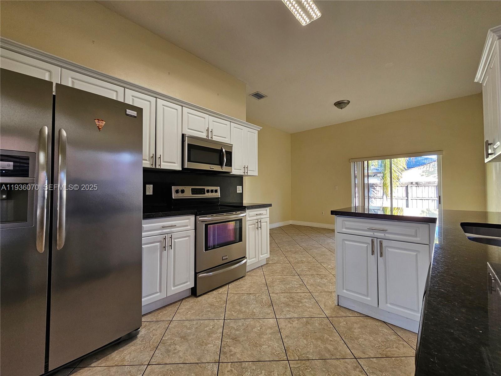 14209 Southwest 160th Court Miami, FL 33196 - Photo 6 of 24 a kitchen with stainless steel appliances granite countertop a refrigerator and a stove top oven