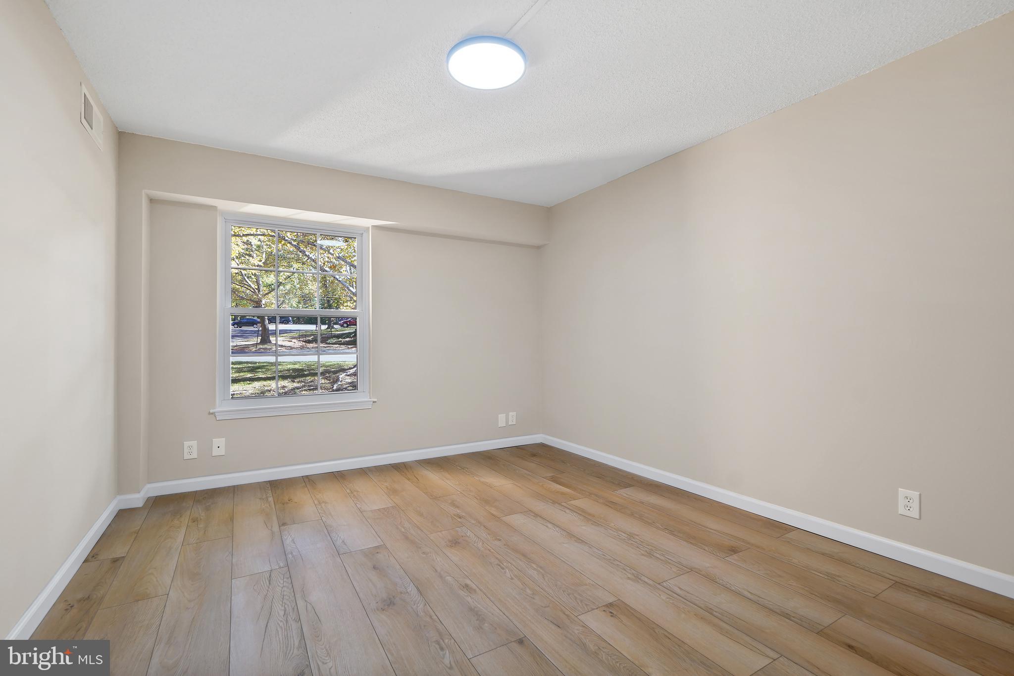 7661 Provincial Drive, Unit 112 McLean, VA 22102 - Photo 15 of 36 an empty room with wooden floor and windows