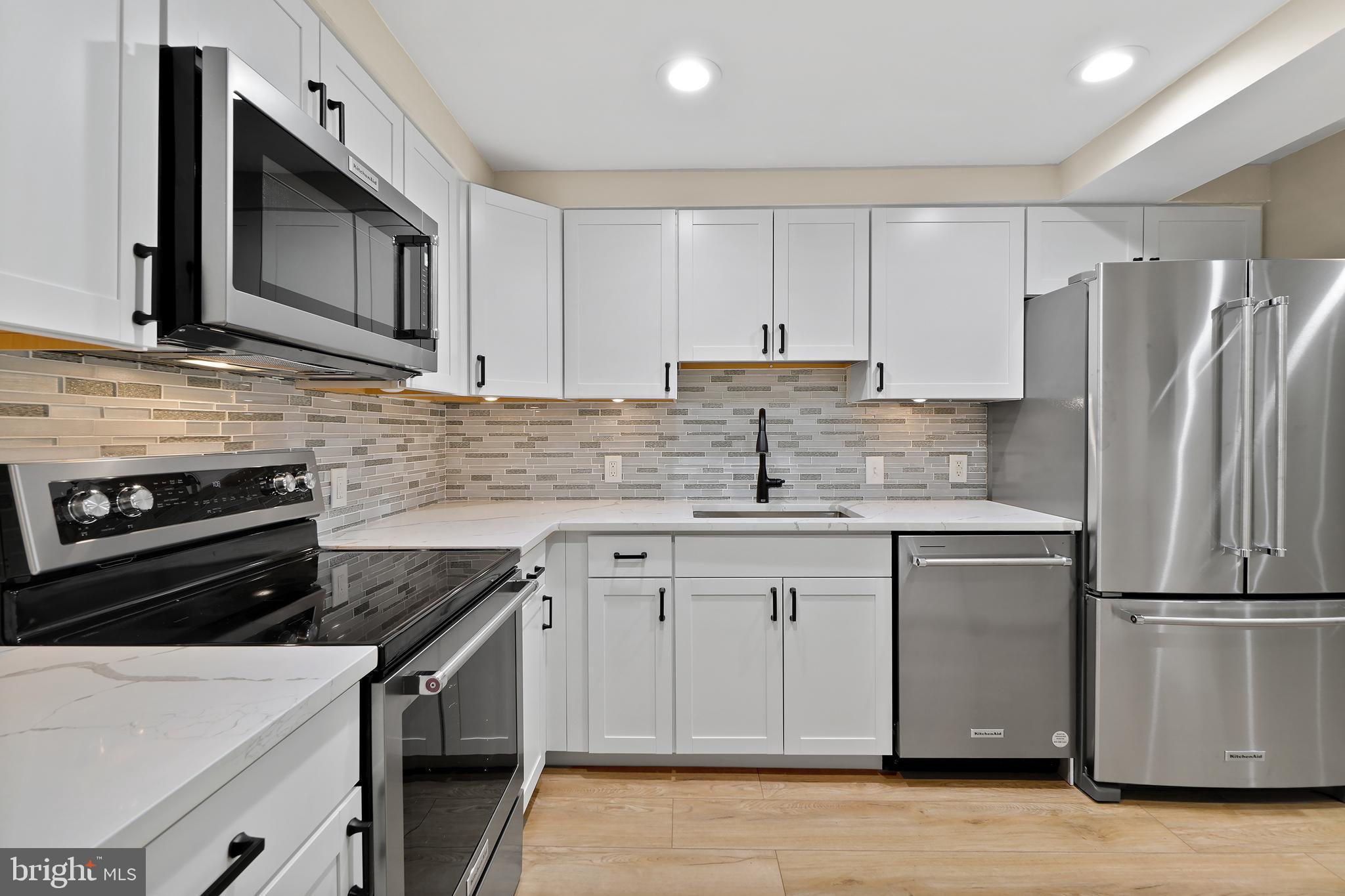 7661 Provincial Drive, Unit 112 McLean, VA 22102 - Photo 8 of 36 a kitchen with stainless steel appliances a sink stove and refrigerator