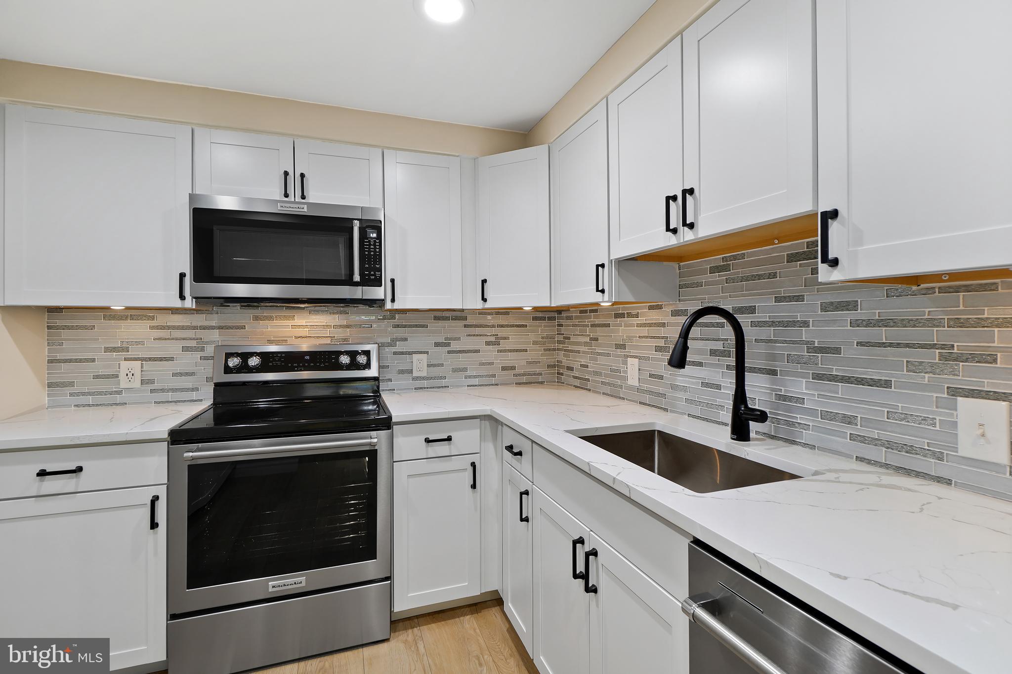 7661 Provincial Drive, Unit 112 McLean, VA 22102 - Photo 9 of 36 a kitchen with cabinets stainless steel appliances a sink and a stove