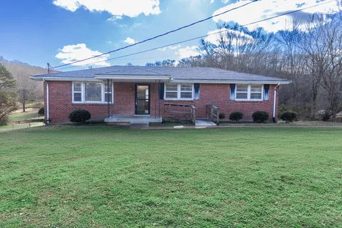 a front view of a house with a garden and yard