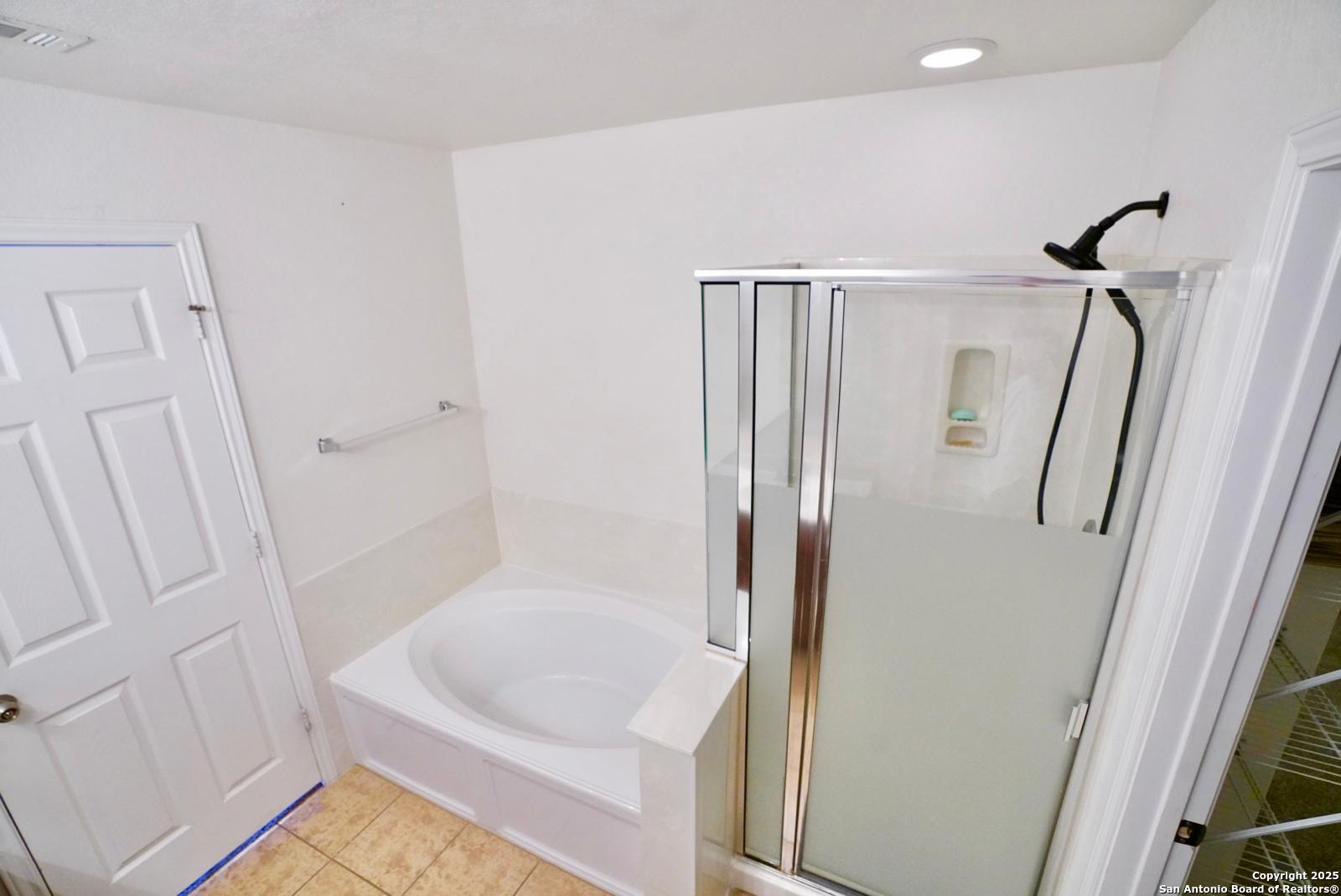 3906 Bent Grass San Antonio, TX 78261 - Photo 17 of 23 a bathroom with a tub a sink and a shower
