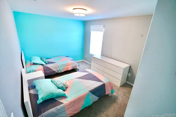 a bedroom with two beds and chair