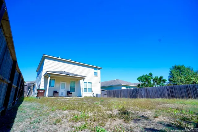 a view of backyard with deck and wooden fence