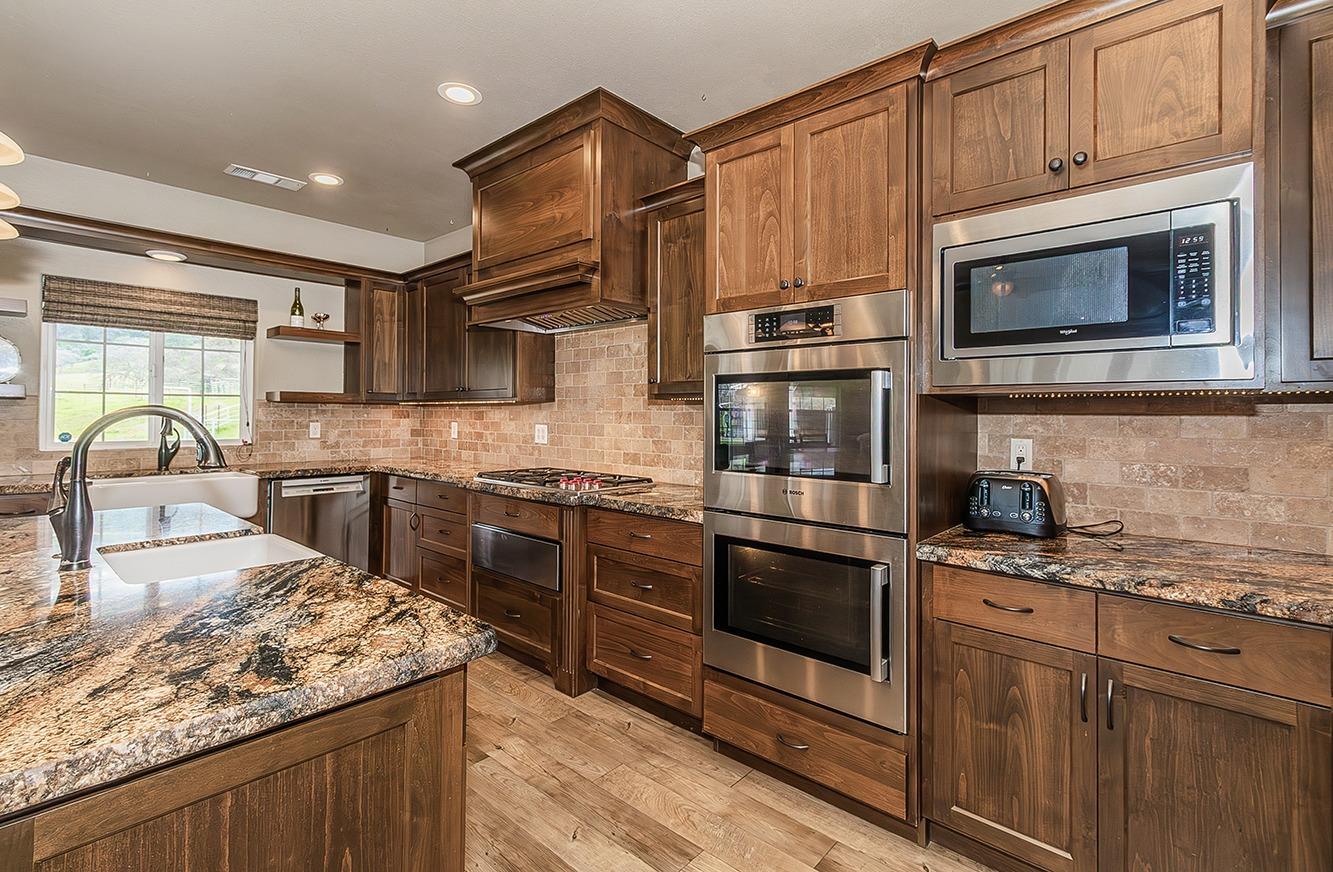 21777 Tollhouse Road Clovis, CA 93619 - Photo 22 of 99 a kitchen with stainless steel appliances granite countertop a stove microwave and sink