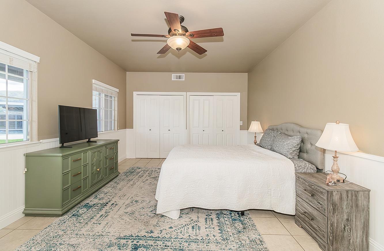 21777 Tollhouse Road Clovis, CA 93619 - Photo 25 of 99 a spacious bedroom with a bed and a flat screen tv