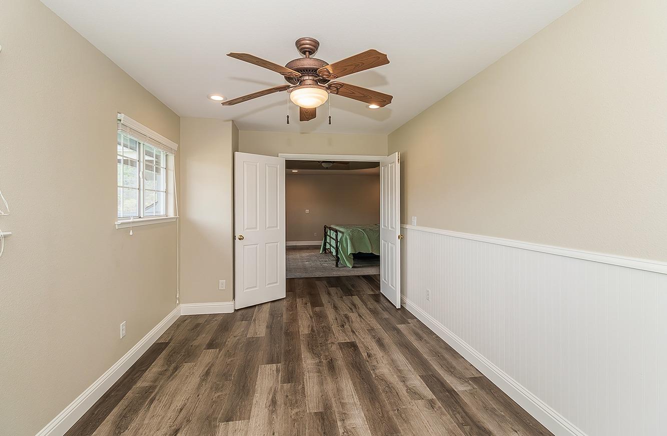21777 Tollhouse Road Clovis, CA 93619 - Photo 55 of 99 a view of a hallway with wooden floor and a ceiling fan