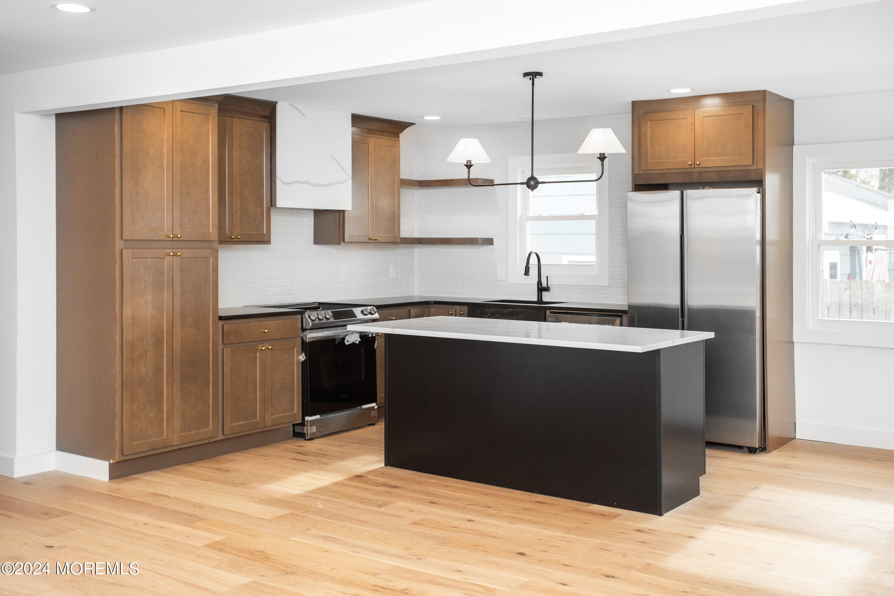 1503 Adrienne Road Wall, NJ 07719 - Photo 7 of 36 a kitchen with a sink a refrigerator and wooden cabinets
