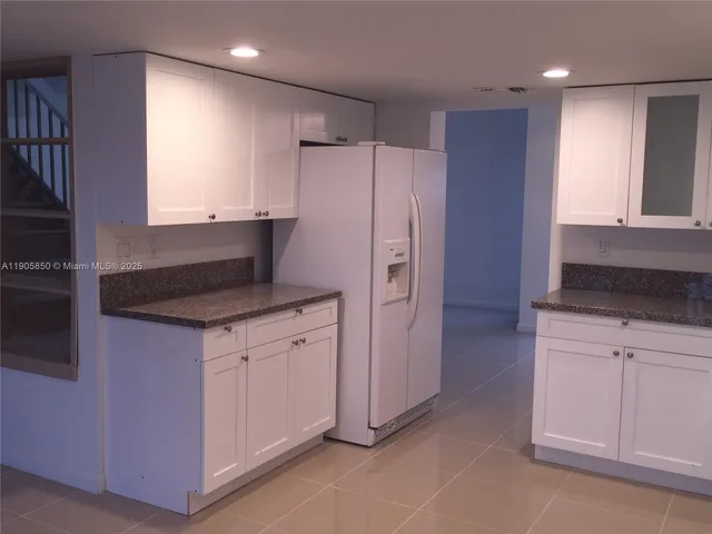 a kitchen with stainless steel appliances granite countertop a refrigerator and a stove