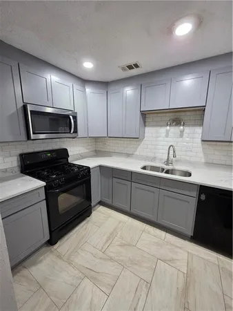 a kitchen with stainless steel appliances granite countertop a sink a stove a refrigerator and cabinets