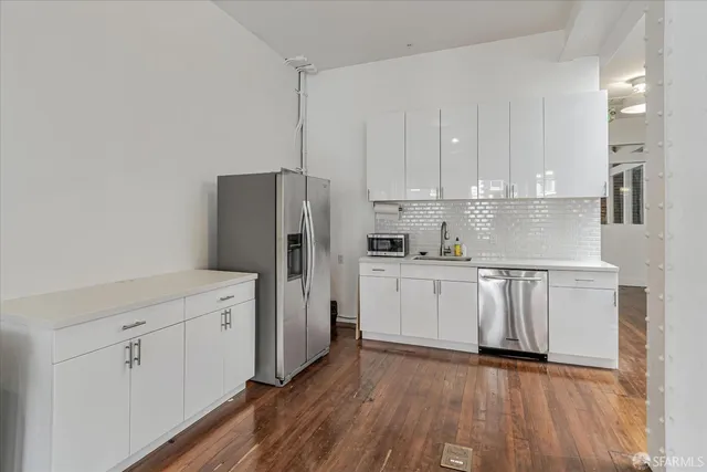 a kitchen with white cabinets and stainless steel appliances
