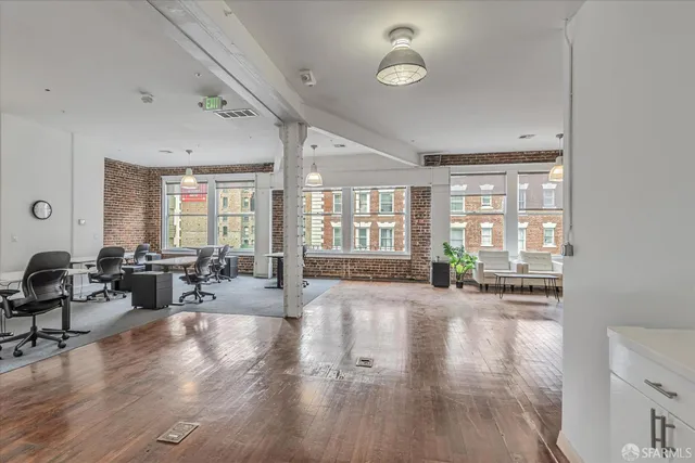 a living room with furniture large window and wooden floor