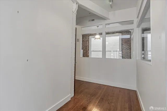 a hallway with wooden floor fireplace and livingroom