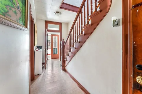 a view of staircase with lots of frames on wall and a window