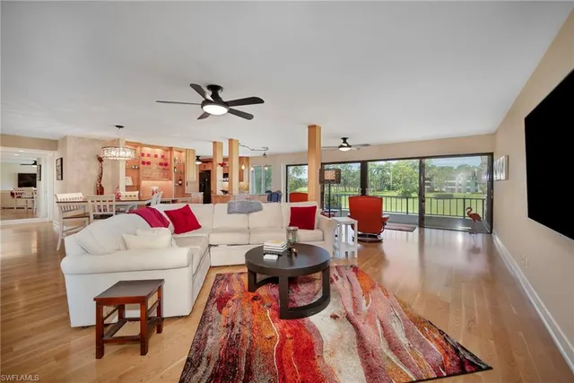 a living room with patio furniture and a large window