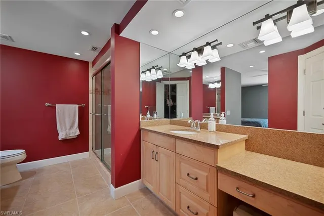 a bathroom with a sink a large mirror and a toilet