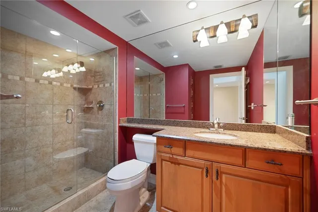 a bathroom with a granite countertop sink toilet and shower