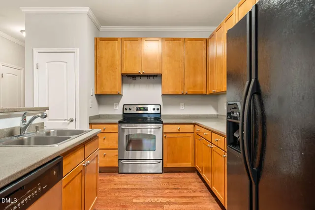 a kitchen with stainless steel appliances granite countertop a refrigerator and a stove top oven