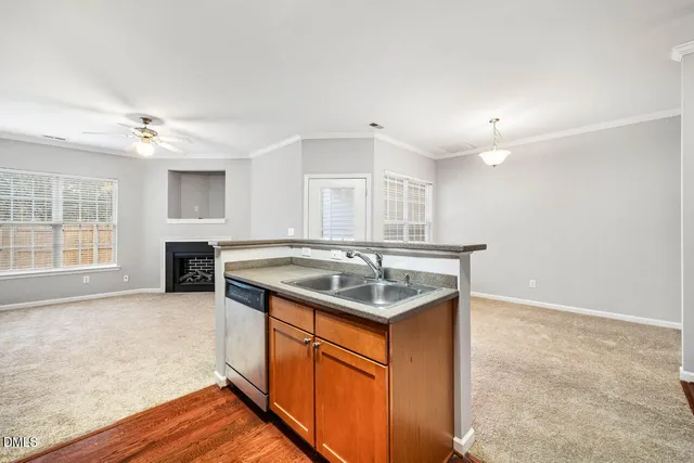 a kitchen with stainless steel appliances granite countertop a refrigerator a sink dishwasher a stove and white countertops with wooden floor