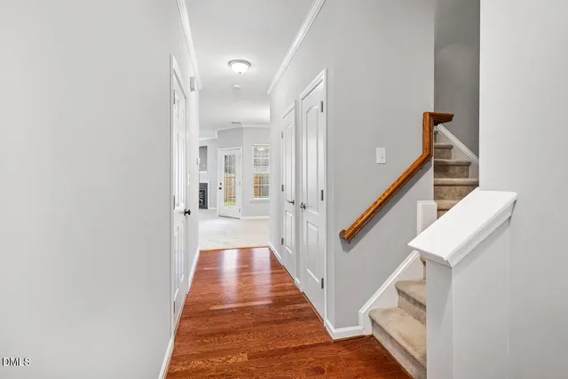 a hallway with white cabinets and wooden floor