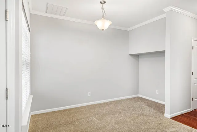 an empty room with windows and cabinet