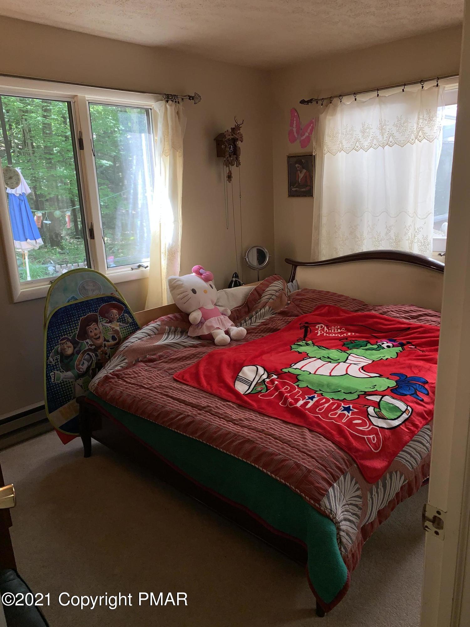 227 Canterbury Road Bushkill, PA 18324 - Photo 15 of 68 a bedroom with a bed a dresser next to a window
