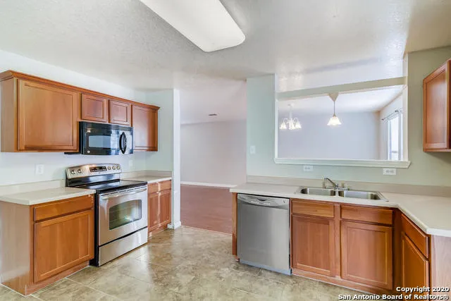 a kitchen with stainless steel appliances granite countertop a sink stove microwave and refrigerator