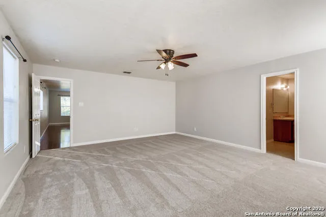 a view of an empty room with a ceiling fan