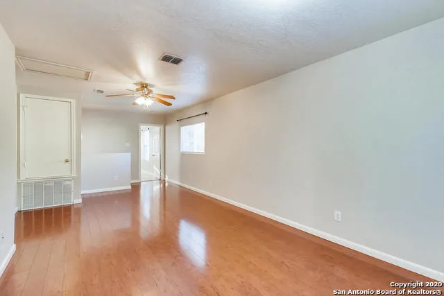 a view of an empty room with wooden floor