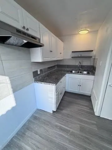 a kitchen with a sink a stove and cabinets