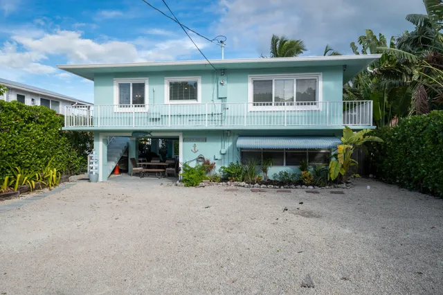 a view of a patio with table and chairs potted plants and palm tree