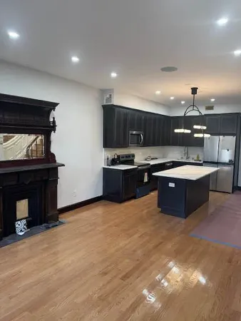 a large kitchen with stainless steel appliances granite countertop a stove and a sink