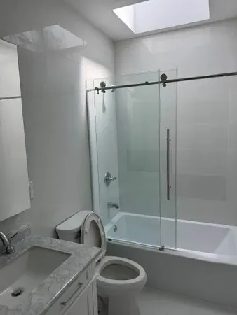 a bathroom with a granite countertop sink a toilet and shower