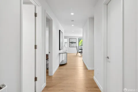 a view of a hallway with wooden floor