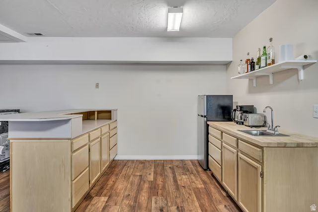 11789 Nicklaus Road Sandy, UT 84092 - Photo 13 of 58 Kitchen featuring open shelves, light wood finish cabinetry, freestanding refrigerator, dark wood-style flooring, and a peninsula