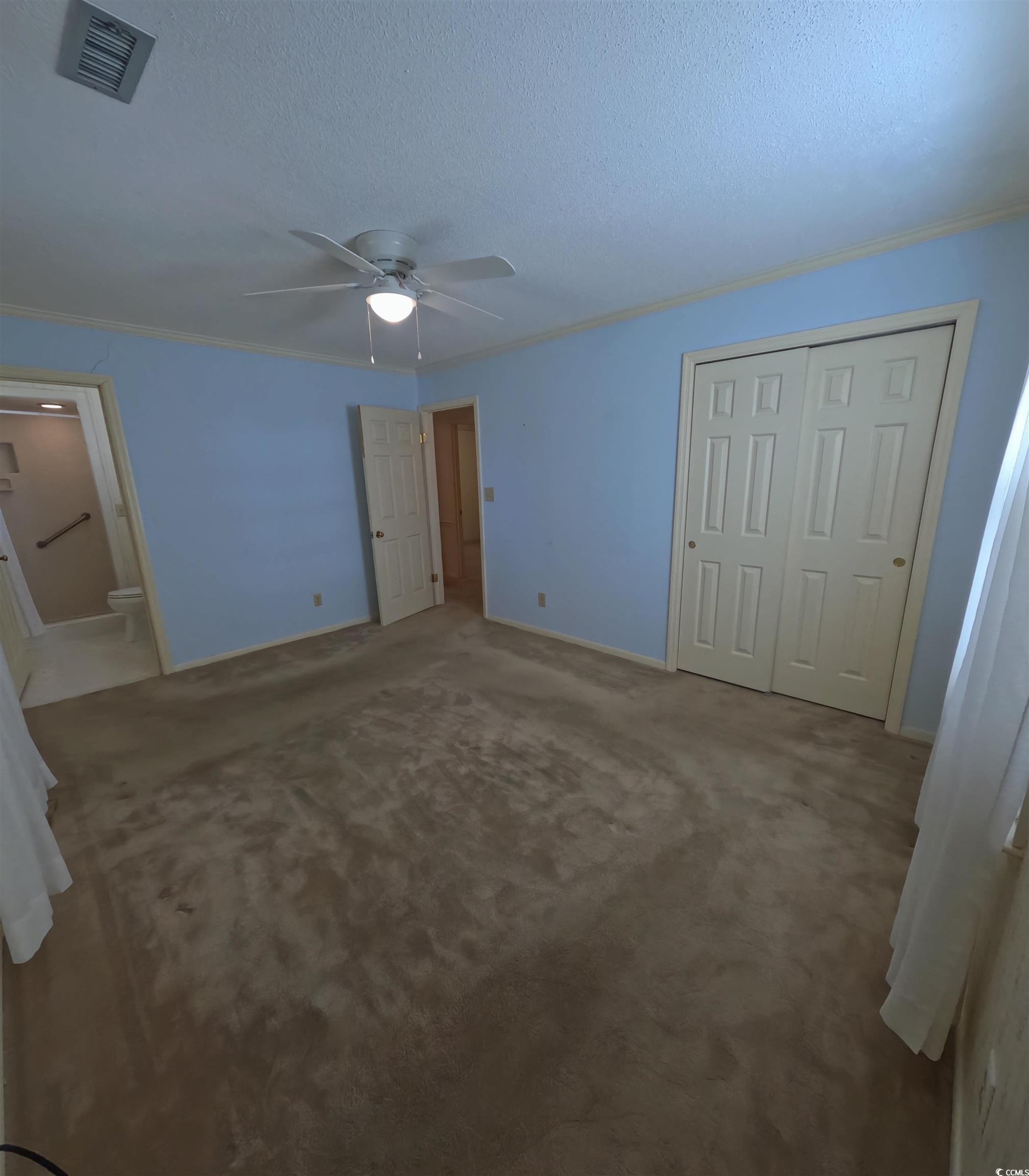 5580 Green Bay Circle Myrtle Beach, SC 29588 - Photo 13 of 36 Unfurnished bedroom with crown molding, carpet floors, a closet, a textured ceiling, and a ceiling fan
