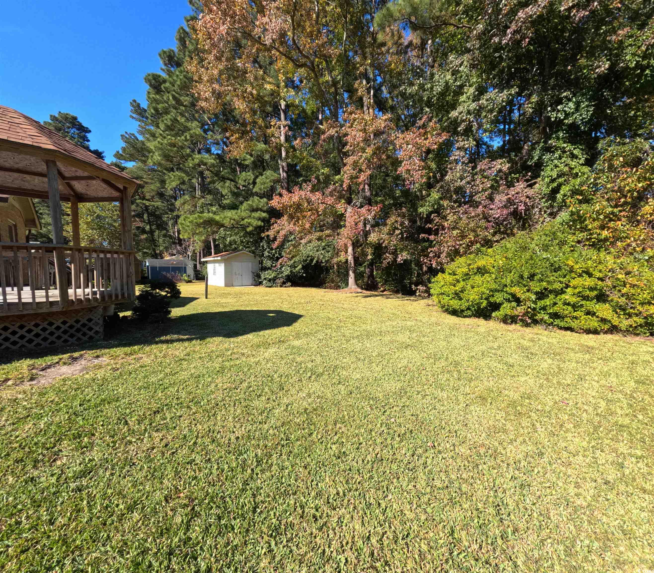5580 Green Bay Circle Myrtle Beach, SC 29588 - Photo 25 of 36 View of green lawn featuring a wooden deck, a gazebo, and a storage shed