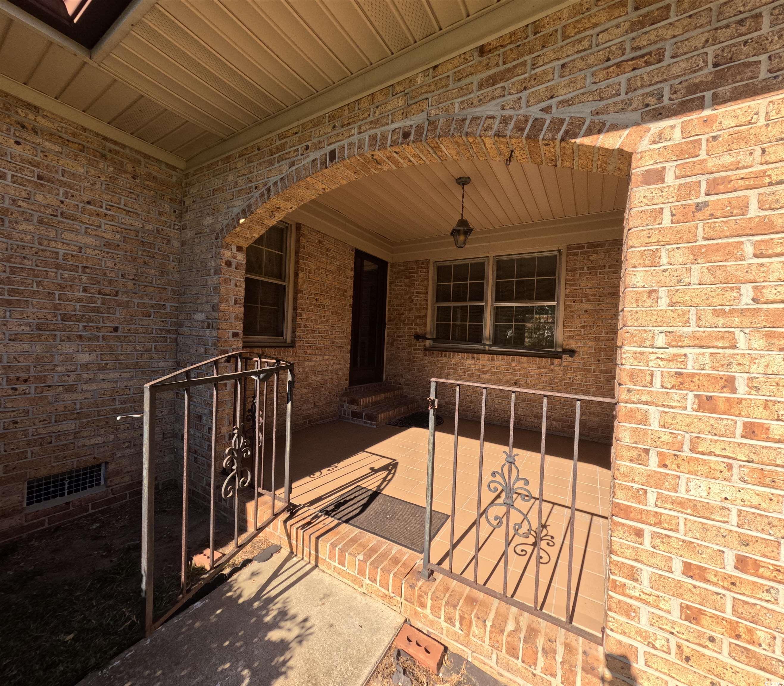 5580 Green Bay Circle Myrtle Beach, SC 29588 - Photo 26 of 36 View of exterior entry with brick siding and a patio area