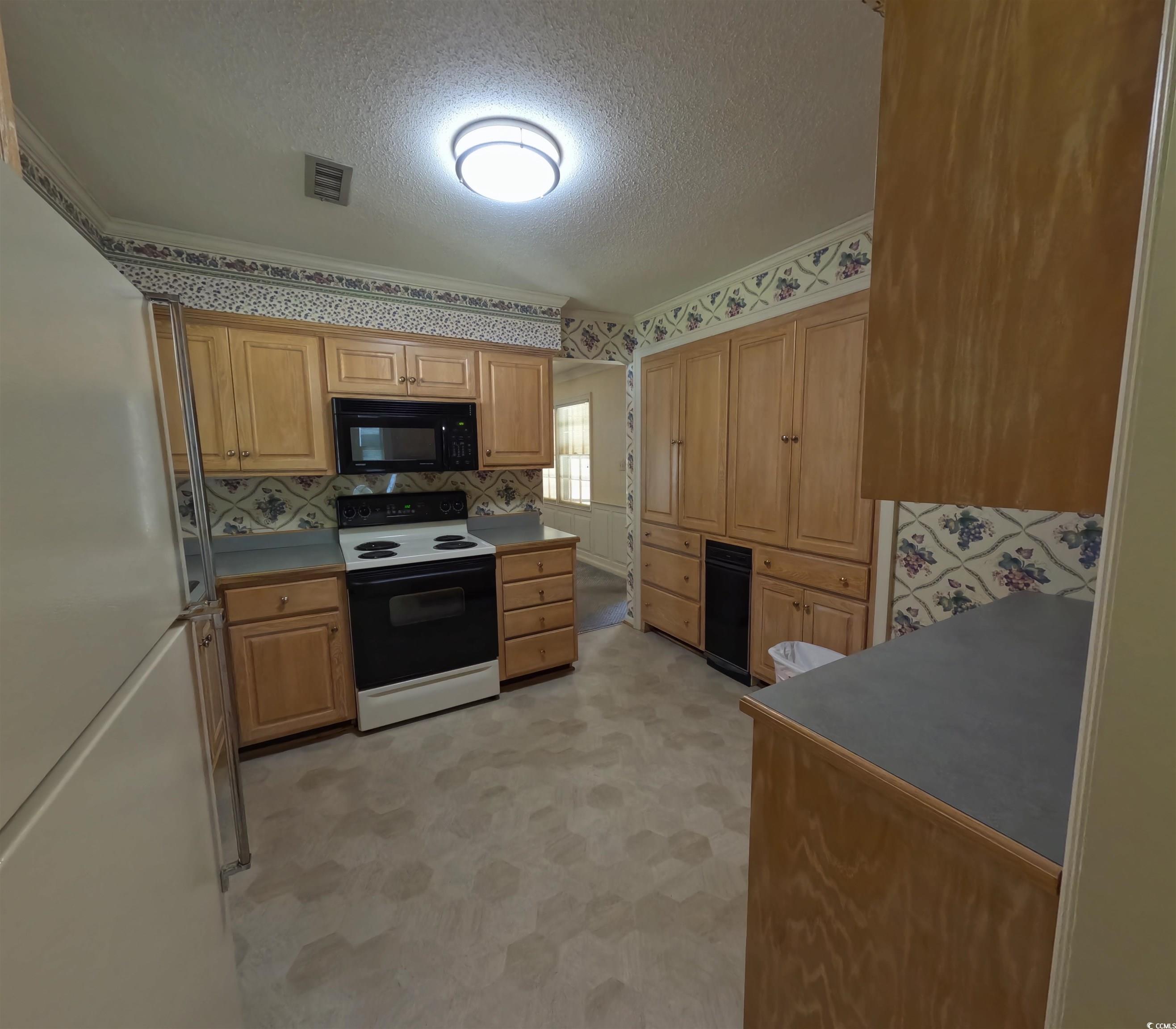 5580 Green Bay Circle Myrtle Beach, SC 29588 - Photo 30 of 36 Kitchen with wallpapered walls, freestanding refrigerator, ornamental molding, a textured ceiling, and electric range