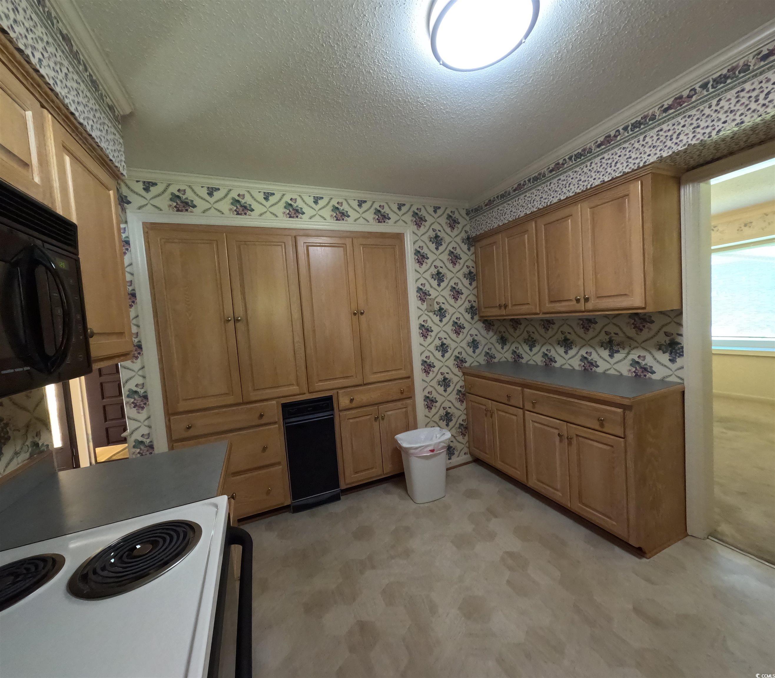 5580 Green Bay Circle Myrtle Beach, SC 29588 - Photo 32 of 36 Kitchen with electric range, a textured ceiling, wallpapered walls, black microwave, and crown molding