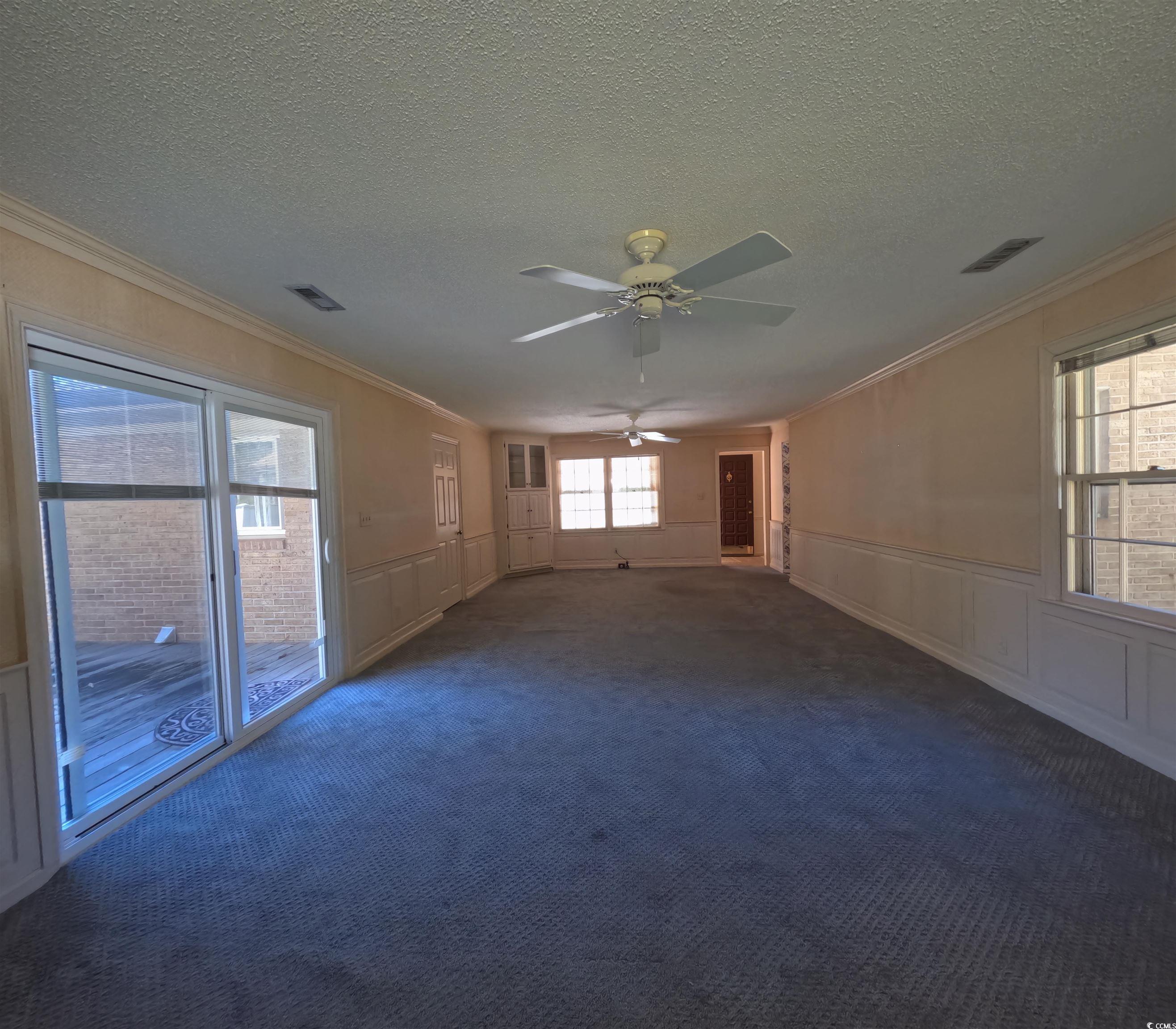 5580 Green Bay Circle Myrtle Beach, SC 29588 - Photo 34 of 36 Carpeted empty room with a decorative wall, a wainscoted wall, ornamental molding, a ceiling fan, and a textured ceiling